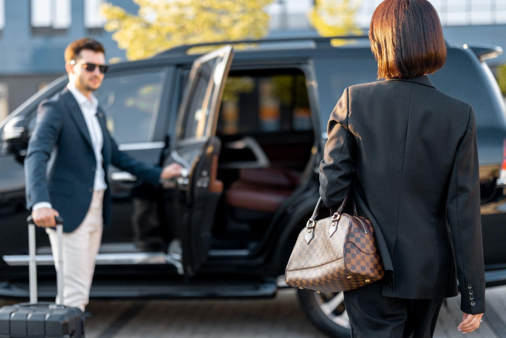 Chauffeur welcoming a traveler beside a black SUV