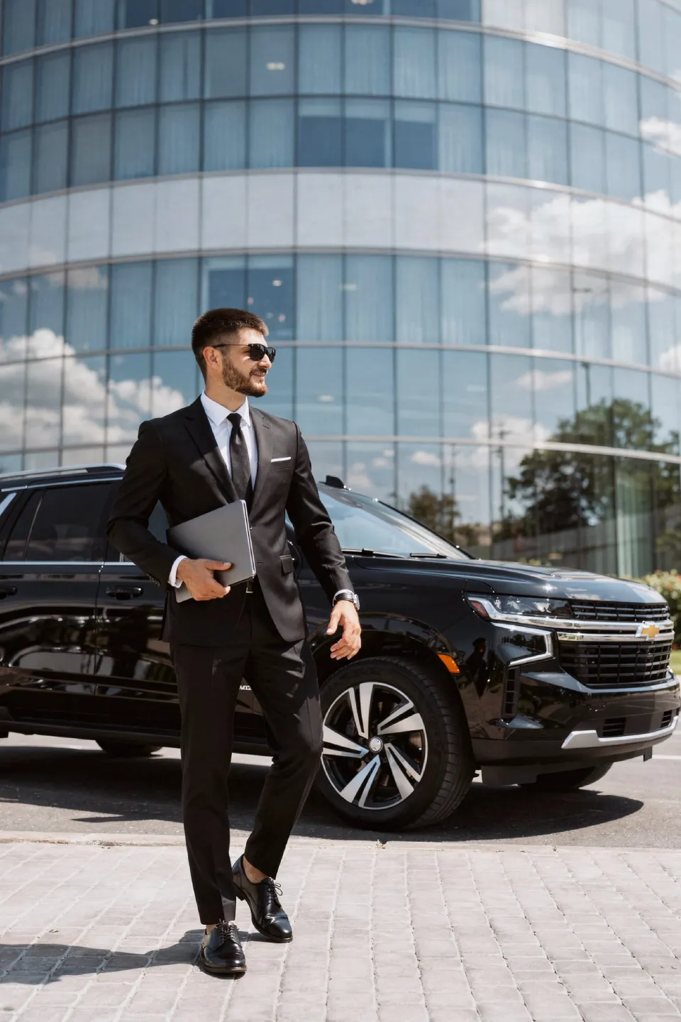 Business traveler beside an executive black car
